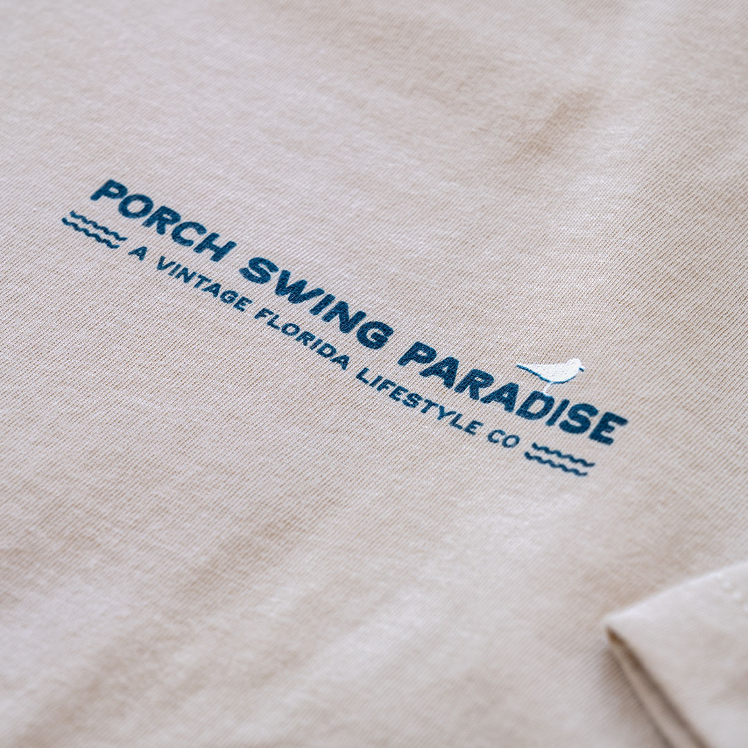Closeup front chest logo view of the back graphic on the Livin' Life on the Line tee in the color cream by Porch Swing Paradise