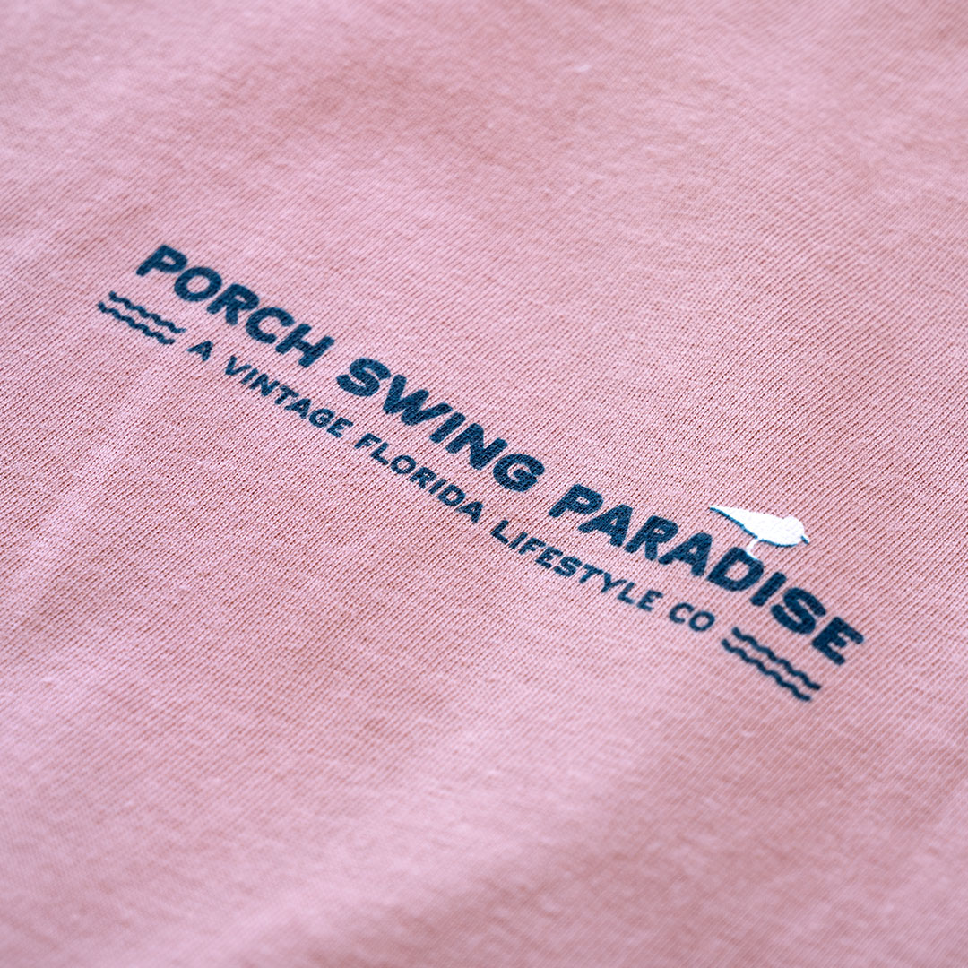 Closeup front chest logo view of the back graphic on the Livin' Life on the Line tee in the color dessert pink by Porch Swing Paradise