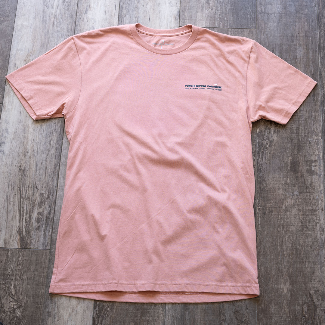 Full front view of the back graphic on the Livin' Life on the Line tee in the color dessert pink by Porch Swing Paradise on a rustic wood backdrop