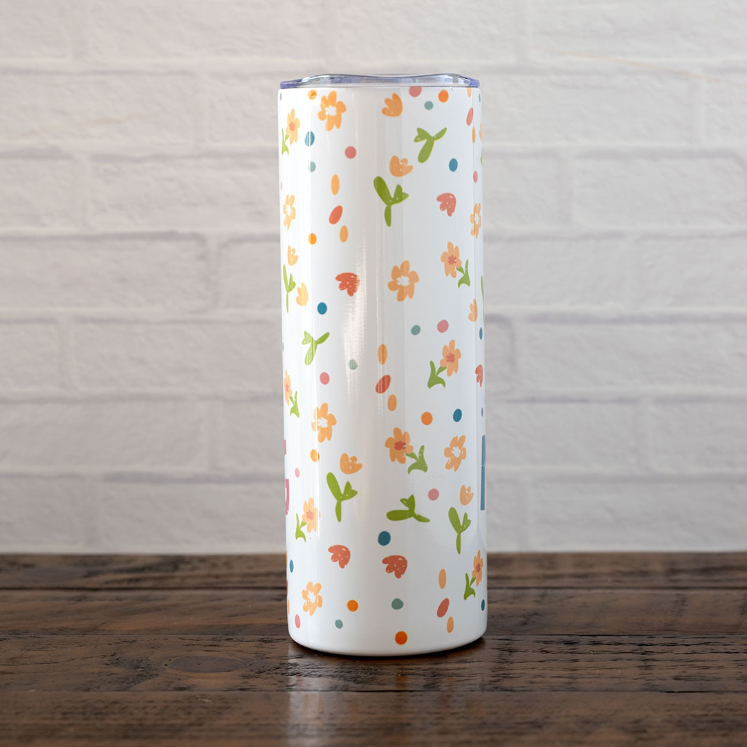 Back view of the Joy Comes in the Morning stainless skinny tumbler against rustic wood backdrop