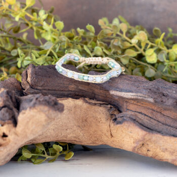 The Natural Wonder of the Moonbeam Bracelet on a piece of driftwood with a rustic backdrop