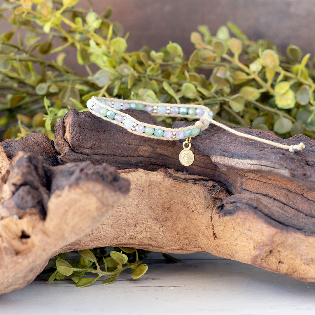 The Natural Wonderside view of the Moonbeam Bracelet on a piece of driftwood with a rustic backdrop