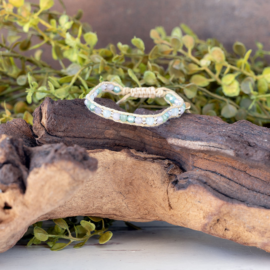The Natural Wonder of the Moonbeam Bracelet on a piece of driftwood with a rustic backdrop