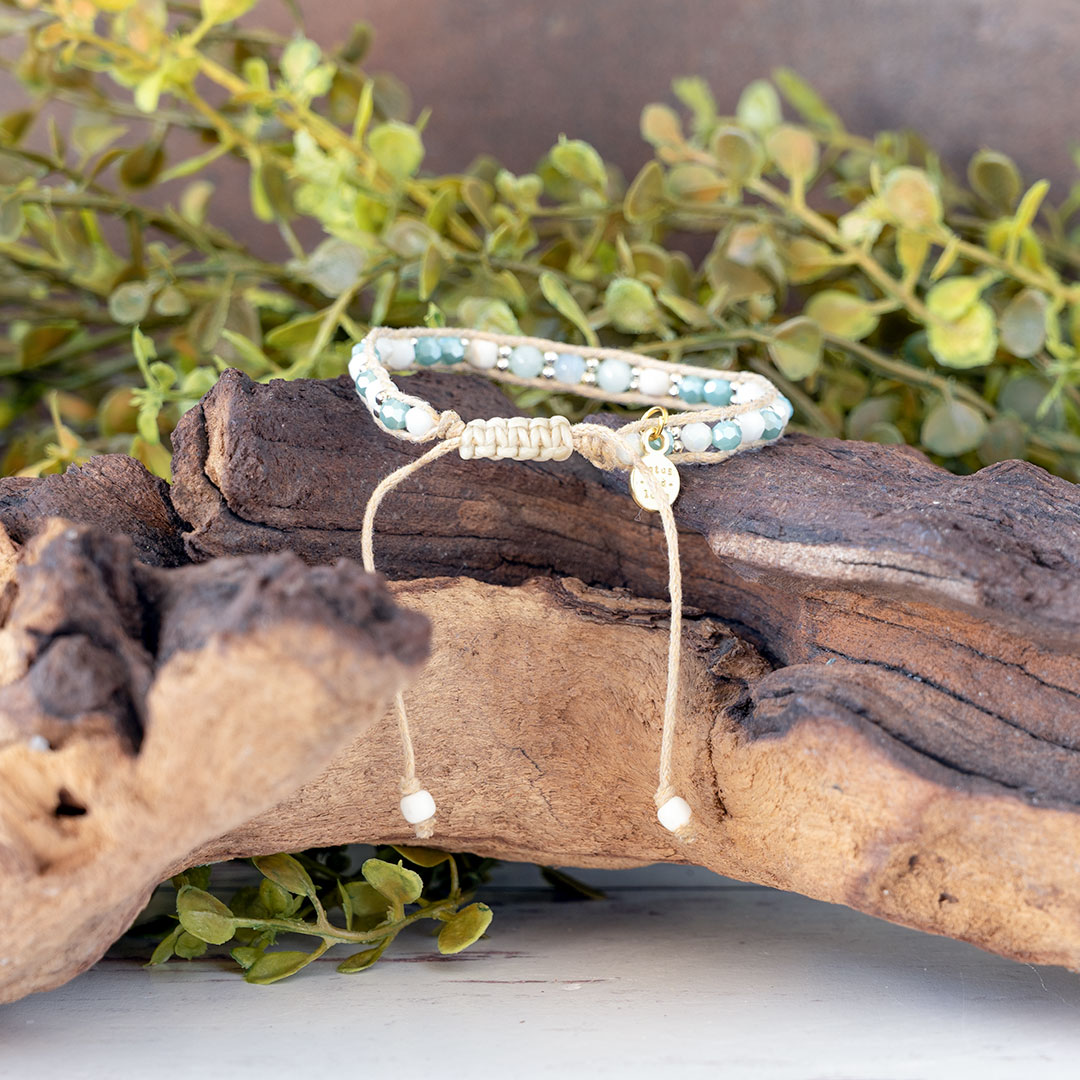 The Pastel Sunrise back view of the Moonbeam Bracelet on a piece of driftwood with a rustic backdrop
