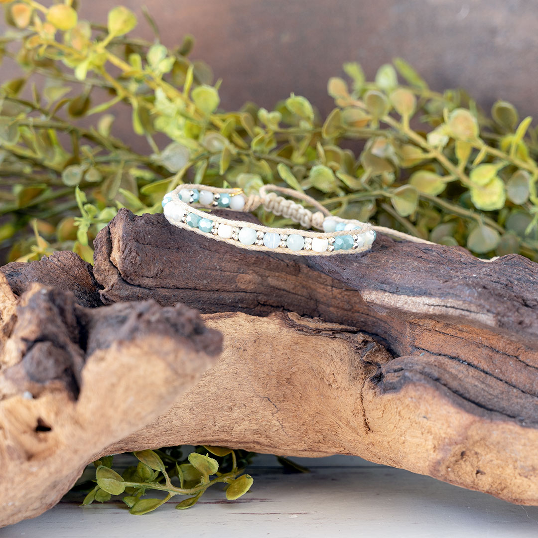 The Pastel Sunrise front view of the Moonbeam Bracelet on a piece of driftwood with a rustic backdrop