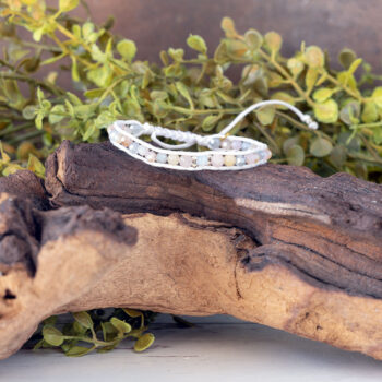 The Pastel Sunrise Front view of the Moonbeam Bracelet on a piece of driftwood with a rustic backdrop